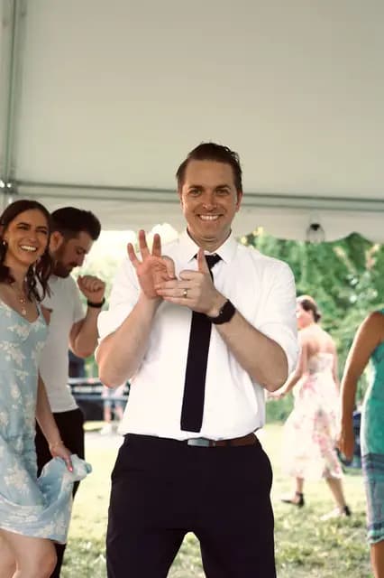 Guest in a tie smiles and dances at the wedding reception