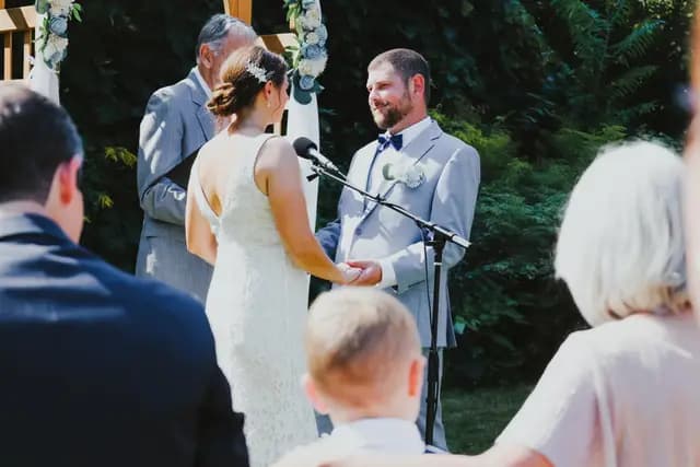 Bride and groom hold hands at the altar during their outdoor ceremony