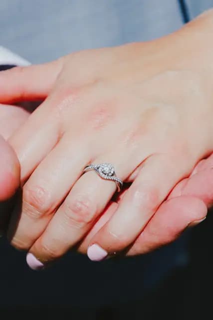 Close-up of the bride's diamond ring as the couple hold hands