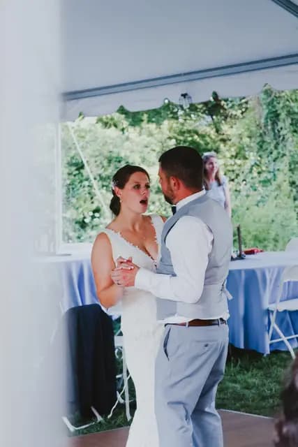 Bride and groom dance together under the tent