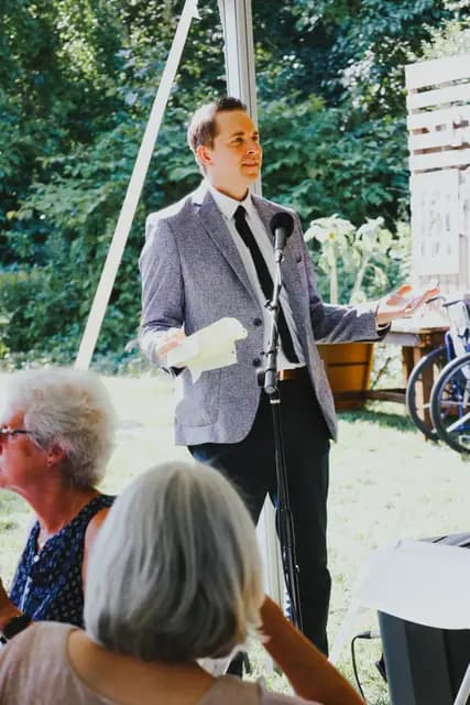 A guest in a tweed jacket gives a speech at the microphone