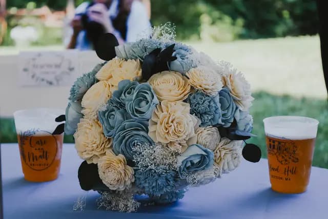 The bride's blue and cream sola-wood bouquet resting on a table