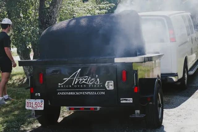 A mobile brick-oven pizza trailer catering the reception