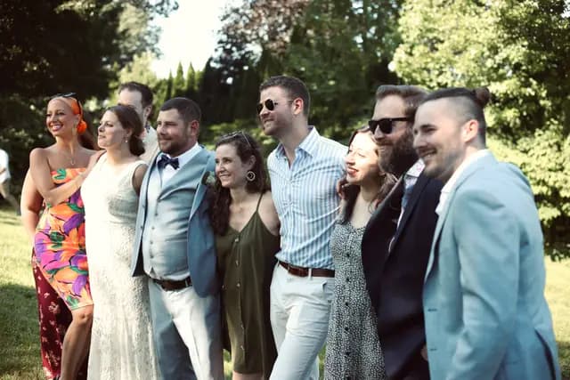 The couple pose with a group of smiling friends outdoors
