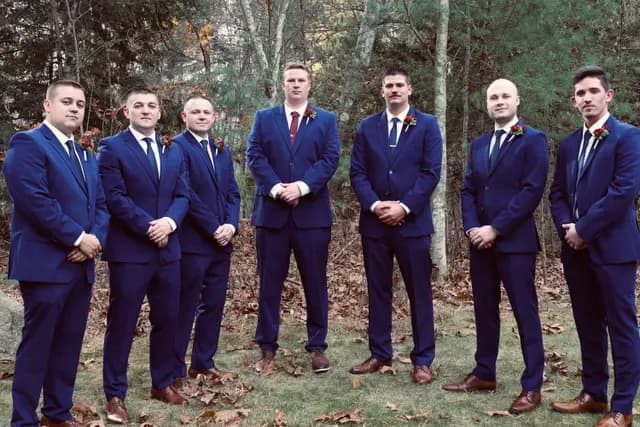 The wedding party of seven lines up in the woods, hands clasped