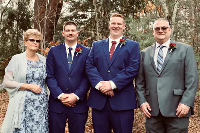 Family portrait with the groom among bare autumn trees