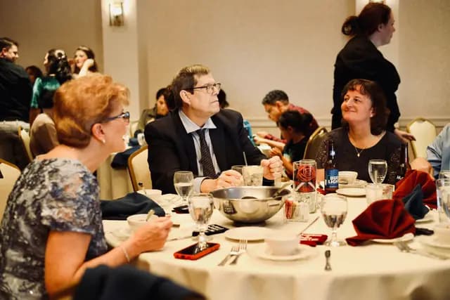 Guests chat around a round table at the ballroom reception
