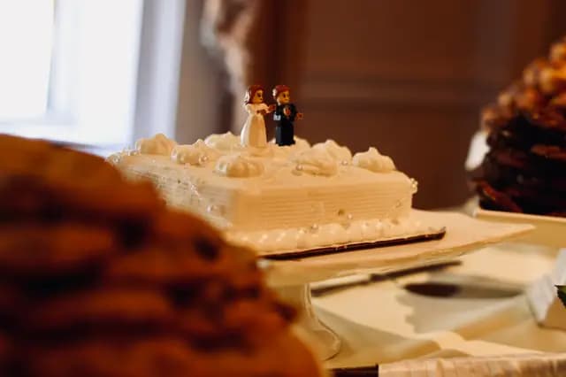 Lego figures top the wedding cake beside trays of cookies