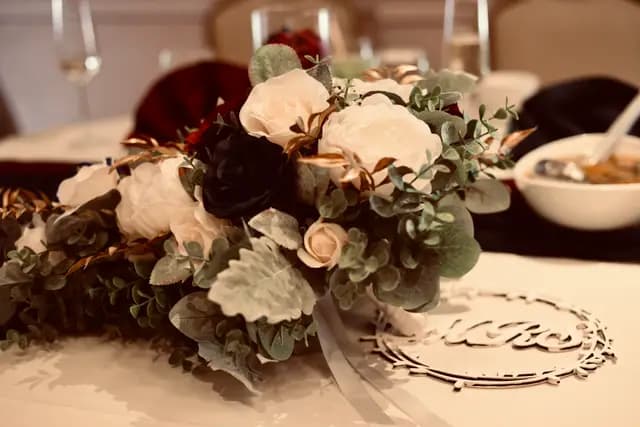 Rose centerpiece and wooden monogram on the head table