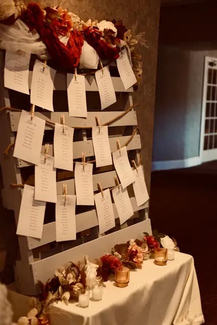 Handwritten table cards on the pallet seating display beside candles
