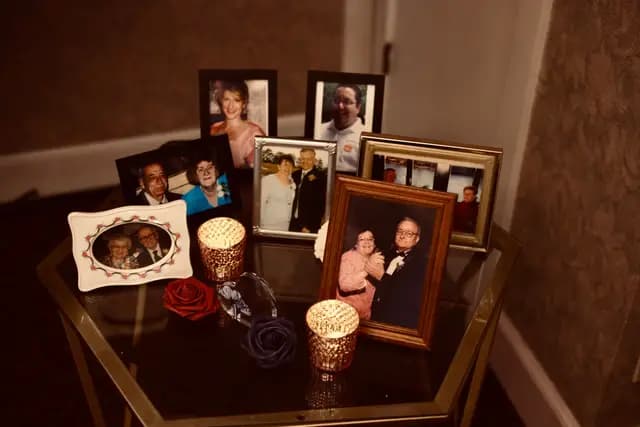 Framed family wedding photos displayed with roses and candles