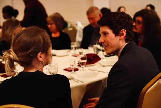 Two guests talk over dinner at the ballroom reception