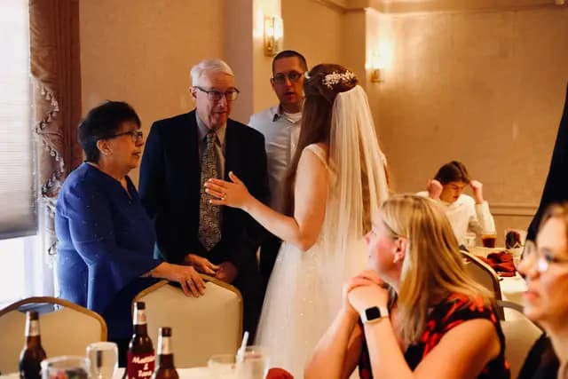 Bride in her veil visits with family at the tables