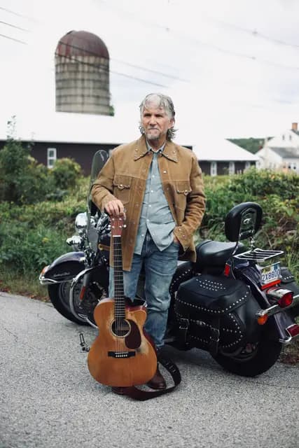 Guitar propped against the bike as the silo looms behind