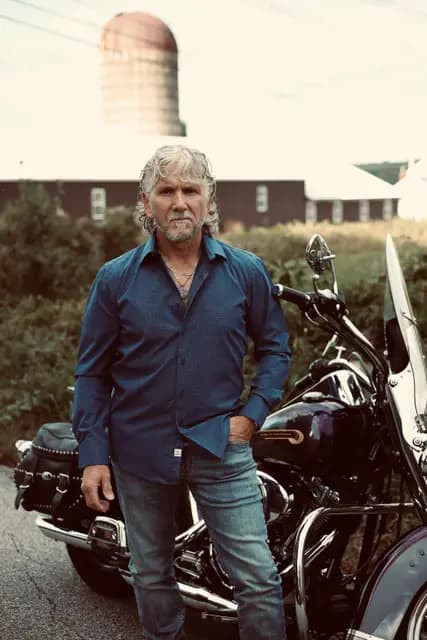 Denim on denim, the artist stands square to the camera