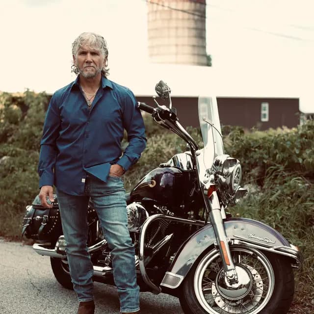 The artist stands over the front wheel, silo in the haze