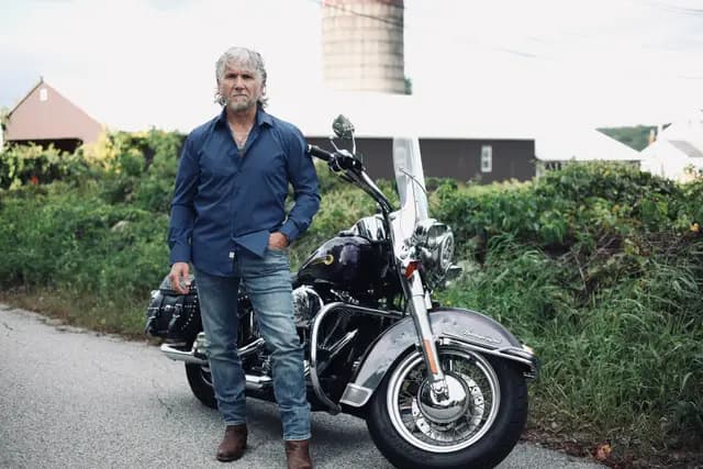 Navy shirt and jeans, standing square in the lane by the bike