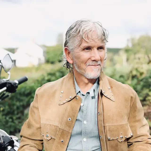 Close portrait in the studded jacket, gaze off to the right