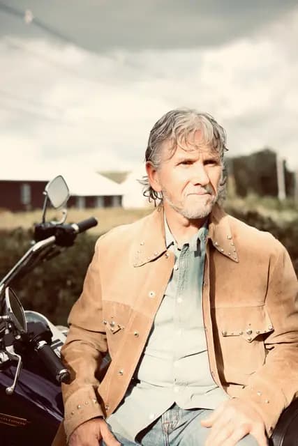 Warm-toned portrait facing the camera from the saddle