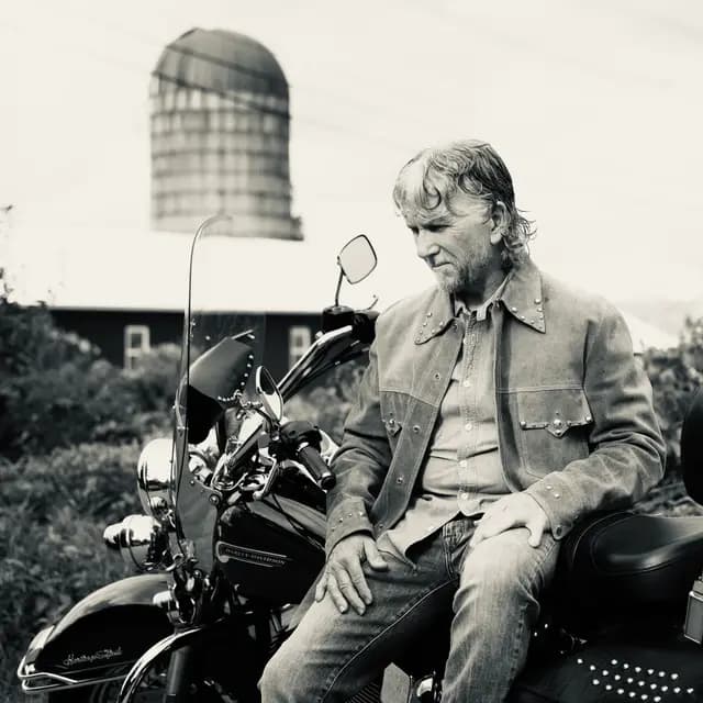 Black and white on the bike beneath the silo, head bowed