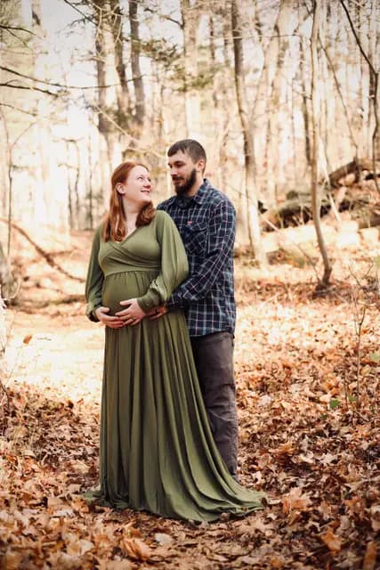 The couple shares a look, hands together on her bump