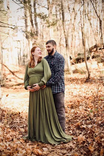 Smiles exchanged among the bare trees, hands cradling the belly