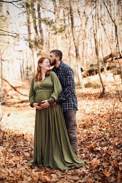 A forehead kiss as they cradle the bump together