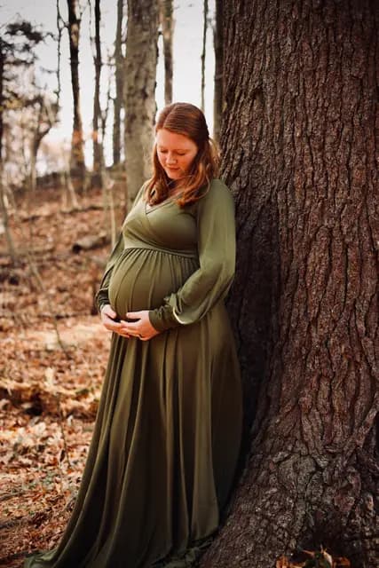Leaning into the bark with eyes lowered to her belly