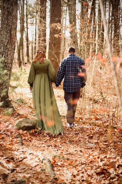 The couple strolls away hand in hand down the leafy trail
