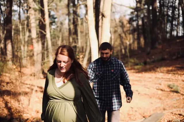 She leads the way along a shaded boardwalk, he follows behind