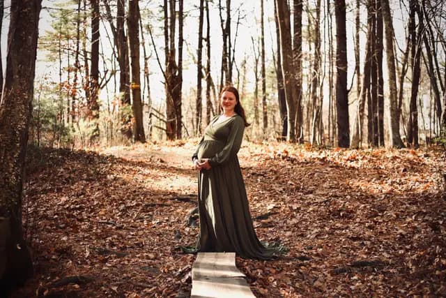 Poised on the narrow boardwalk with hands at her bump