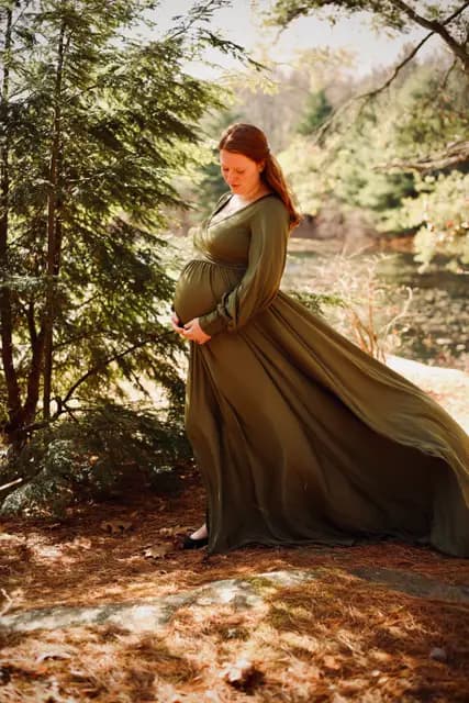 Looking down at the bump as the gown billows by the water