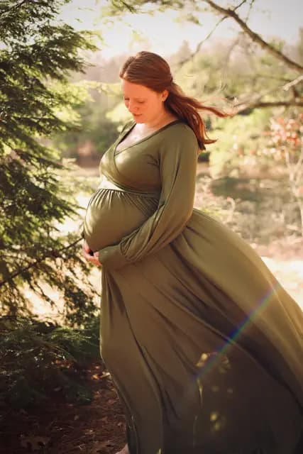 A breeze lifts her hair beside the hemlock boughs