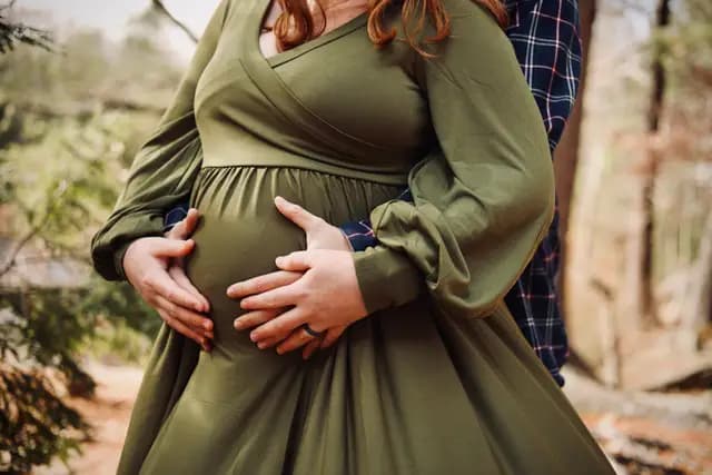 Close detail of both their hands wrapped around the bump